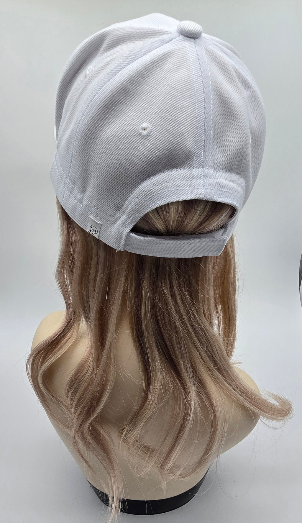 Casquette blanche et cheveux naturels blonds